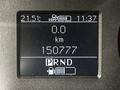 A digital dashboard display showing the temperature at 21.5°C a mileage of 0.0 km and an odometer reading of 150777 with a gear selector indicator