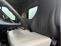 The interior of a 2007 Freightliner FLD120 truck featuring a black driver's seat and a light-colored passenger seat with a steering wheel visible in the foreground
