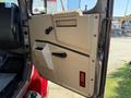 The door of a 1991 International 4600 truck featuring an angular design with a handle and a red light on the lower portion
