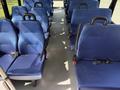 Interior of a 2020 Chevrolet Express van featuring several rows of blue fabric seats with seat belts