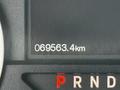 Close-up of a digital odometer displaying 69563.4 kilometers on a vehicle dashboard