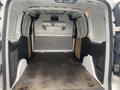 Interior view of a 2017 Ford Transit Connect cargo van showcasing an empty load space with metal and plastic paneling and a mesh partition