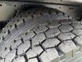 Close-up of a treaded tire from a 1998 Freightliner FL80 showing worn rubber and distinct patterns designed for traction