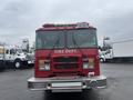A red 2006 E-One fire truck is shown from the front with emergency lights on top and "FIRE DEPT" displayed prominently on the grille