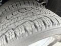 Close-up of a worn tire from a 2015 Ford F-350 SD showing deep tread patterns and visible signs of use