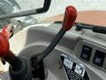 Close-up of a red and black gear shift lever on a 2011 Kubota M8540D tractor's control panel