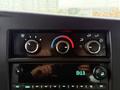 Control panel of a 2021 Chevrolet Express featuring knobs for climate control and a digital clock display
