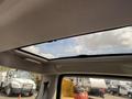 View of the interior sunroof of a 2006 Land Rover LR3 with clouds visible through the glass ceiling
