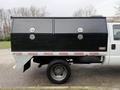A 2016 Ford F-550 Super Duty with a dual black storage compartment in the truck bed and a silver truck bed feature