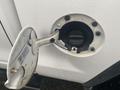 Close-up of the fuel cap on a 2015 GMC Sierra 1500 with the cap slightly open and visible fuel filler neck inside