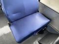 A blue fabric seat inside a vehicle designed for passenger comfort with a slightly worn surface