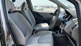 Interior view of a 2006 Honda Fit showing front seats and steering wheel with cloth upholstery and a standard dashboard layout