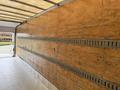 Interior of a 2017 Hino 338 truck showing wooden walls with metal track systems for securing cargo