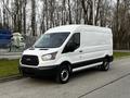 A 2017 Ford Transit van in white with a black front grille and wheels is parked facing slightly to the right