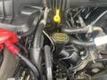 Close-up of the engine compartment of a 2017 Ford F-550 showing various hoses and components including a yellow oil cap labeled SAE 5W-20