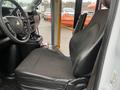 Interior view of a 2018 Chevrolet Express featuring a driver's seat with black fabric upholstery and a dashboard displaying controls and cup holders