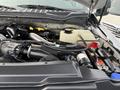 Engine compartment of a 2017 Ford F-450 Super Duty showing various components including hoses battery and coolant reservoir