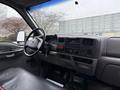 Interior view of a 2000 Ford F-450 featuring a black dashboard radio controls steering wheel and assorted buttons and gauges