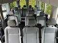 Interior view of a 2017 Ford Transit 350 showing rows of gray seats with seatbelts arranged for passenger transportation