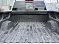 A 2017 Chevrolet Silverado 1500 truck bed with a textured black surface and a Chevrolet emblem visible on the tailgate