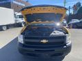 A 2013 Chevrolet Silverado 1500 with its hood raised displaying the engine compartment and various mechanical components