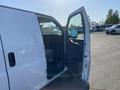 A white 2012 GMC Savana van with the driver's side door open showcasing the interior seating and dashboard area