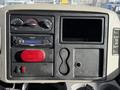 Dashboard of a 2010 International 4300 featuring controls knobs a CD player a red light and storage compartments