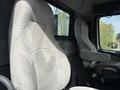 Interior view of a 2012 Volvo VNL showcasing two truck seats one is gray fabric with a patterned design and the other is a solid gray fabric