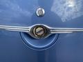 Close-up of the emblem on a 2007 Chrysler PT Cruiser showing the chrome and gold design with the Chrysler logo in the center