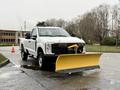 A 2023 Ford F-250 pickup truck equipped with a yellow snow plow attached to the front