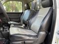 Two seating positions in the front of a 2012 Dodge Ram 5500 truck featuring black and gray upholstery with a console in between