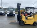 A yellow 2010 Hyster S80XLBCS forklift with a black mast and two forks in the front positioned on a wet surface
