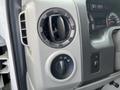 A close-up of the dashboard controls of a 2009 Ford Econoline featuring an air vent and knobs for light and power adjustments