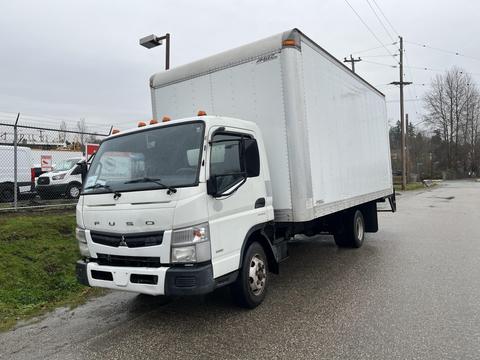 A 2012 Mitsubishi Fuso FE truck with a white box cargo container parked on a street