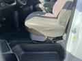 Interior view of a 2016 GMC Savana showing the driver's seat with brown fabric and a black rubber floor mat