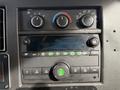 Dashboard controls of a 2019 Chevrolet Express featuring climate control knobs and a radio interface with various buttons and a display screen
