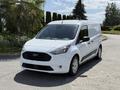 A white 2021 Ford Transit Connect van facing forward with a black grille and alloy wheels parked on a driveway
