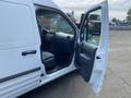 A white 2013 Ford Transit Connect with the driver's side door open revealing the interior and dashboard