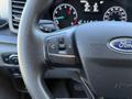 Steering wheel of a 2022 Ford Transit featuring audio control buttons and the Ford logo