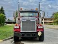 Red 2007 Freightliner FLD120 truck with large chrome exhaust stacks and front grill visible headlights and orange cab lights