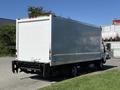 A 2018 Hino 195 box truck with a white cargo area and black lower section parked with its back view visible