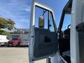 A white 2007 International 7300 truck with its driver's door open showcasing the interior and mirror