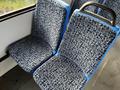 Two bus seats covered in a floral patterned fabric with a blue frame