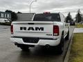 A 2022 RAM 1500 Classic pickup truck with a white exterior parked on the side of the road showing the rear view and the RAM logo on the tailgate