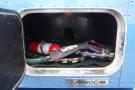 A blue truck compartment with a fire extinguisher and colorful hoses inside