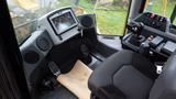 Interior of a 2019 Caterpillar 972M XE with a seat control panel display pedals and armrest controls visible