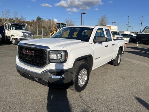 A white 2018 GMC Sierra 1500 pickup truck with a black grille and chrome accents parked at an angle facing the viewer