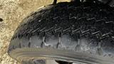 A close-up of a worn tire from a 2007 Ford F-550 showing deep treads and signs of wear on the rubber surface