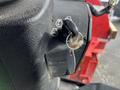 A close-up of the ignition key switch of a 2014 John Deere 1585 Terrain Cut with a key and a small piece of debris attached