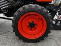 Close-up of a tire with an orange rim from a 2018 Kubota B2650 tractor showing distinct tread patterns and bolts